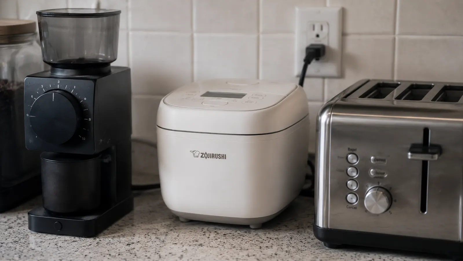 The Dash Mini Rice Cooker's short power cord reaching to a nearby outlet on a small counter